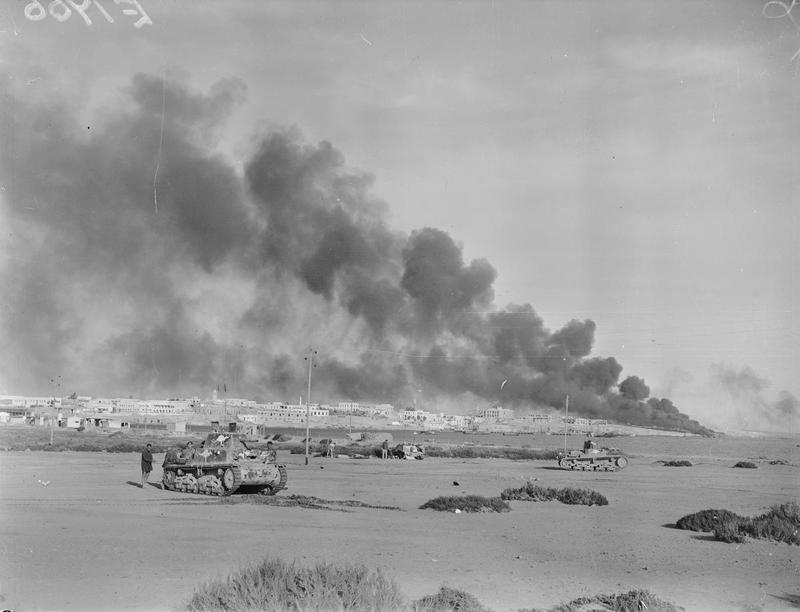 Port installations burn over the harbour town of Tobruk, 24 January 1941 (IWM E1766)